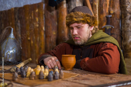 Portrait of man in russian ethnic suit playing chess photo