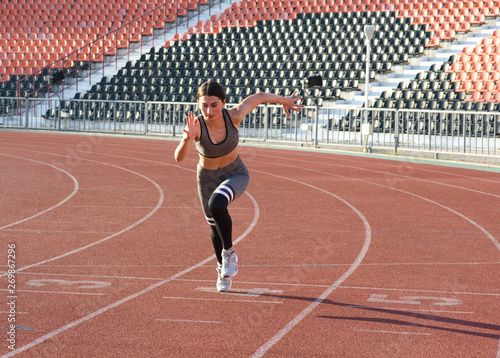 Beautiful athletic girl running around the stadium © Павел Костенко