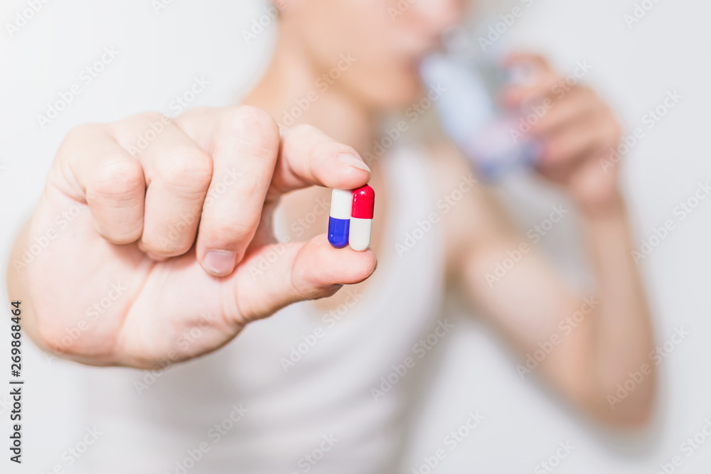 Hand holding capsule medicine and glass of water for takes medicines treat illness close up on capsule shallow DOF Hand holding capsule medicine and glass of water for takes medicines treat illness close up on capsule shallow DOF