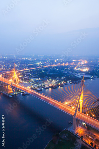 Aerial view of Bhumibol Suspension Bridges and highways interchange over the Chao Phraya River at dusk. Samut Prakan, Thailand.