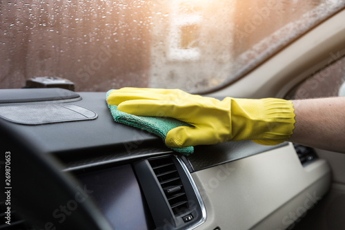 Cleaning service. Man in uniform and yellow gloves washes a car interior in a car wash © xartproduction