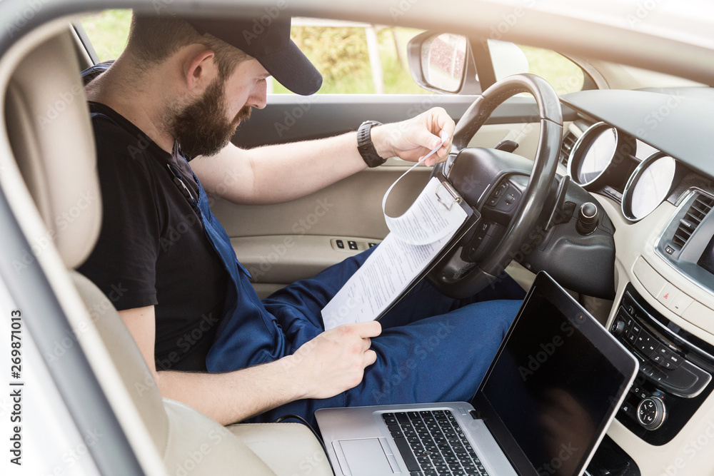 Obraz premium Professional car mechanic working in auto repair service. Computer video investigate. Engine diagnostics. Service station.