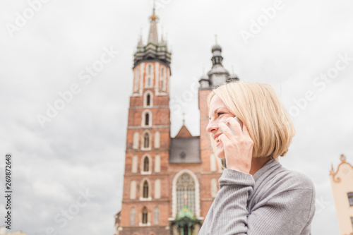 Young beautiful woman on the background of the St. Mary's Church in Krakow