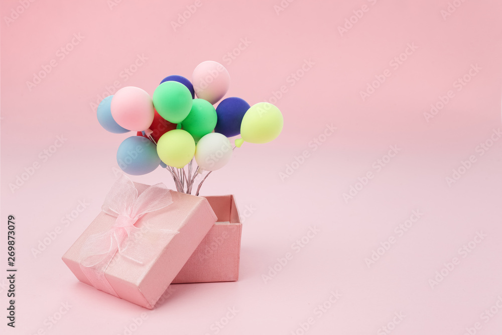 Pink gift box with colorful balloon on pink background. minimal hollyday concept.