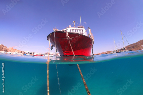 Underwater sea level photo of idilic pebble beach of Karavostasis, picturesque port of Folegandros island with traditional fishing boats docked and crystal clear turquoise sea, Cyclades, Greece photo