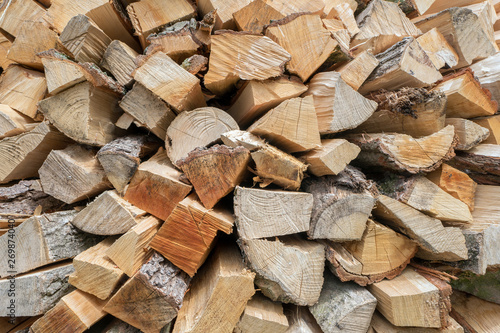 Background of dry chopped firewood logs in a pile.