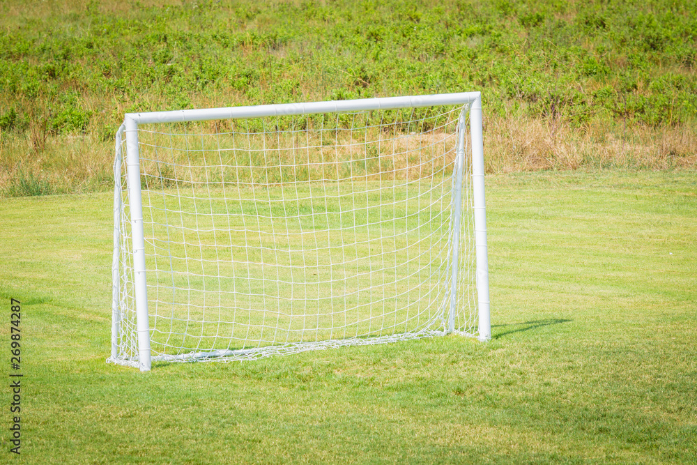 Fototapeta premium Football goal with net for playing on green grass.