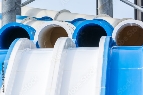 Water slides of white and blue pipes in aquapark.