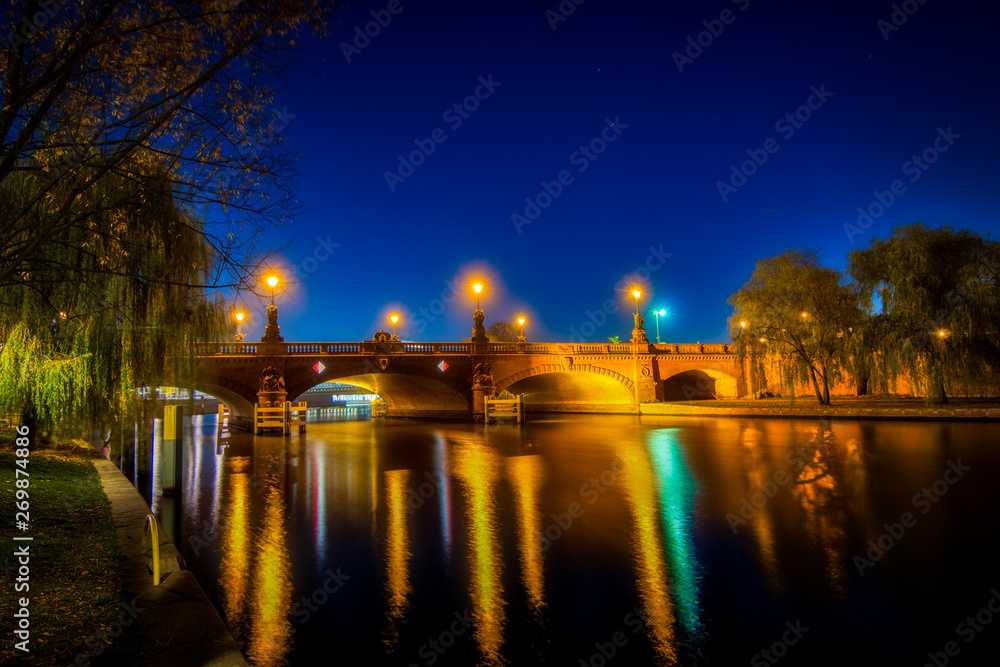 Nachtaufnahme der Moltkebrücke in Berlin bei Nacht mit bunten Lichtern und Reflexionen auf der Wasseroberfläche