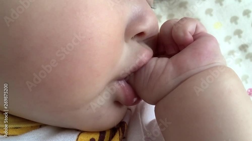 A female baby sucking a finger and sleeping
