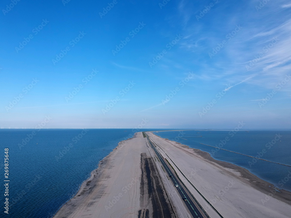 Drone photo of the markerwaard dike that connects Enkhuizen with lelystad. The sand has been sprayed on for dyke improvement and a new nature area has also been created.