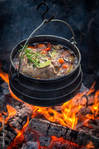 Delicious and fresh hunter's stew with vegetables on bonfire