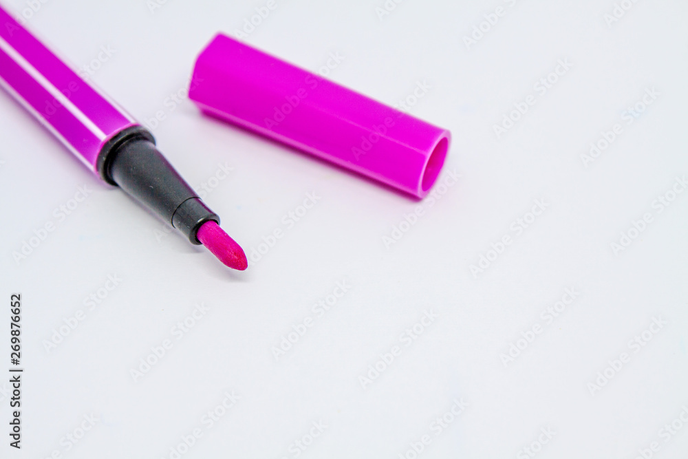 A piece of a felt marker pen and its cap are next to it on a white background. A piece of a felt marker pen and its cap are next to it on a white background.