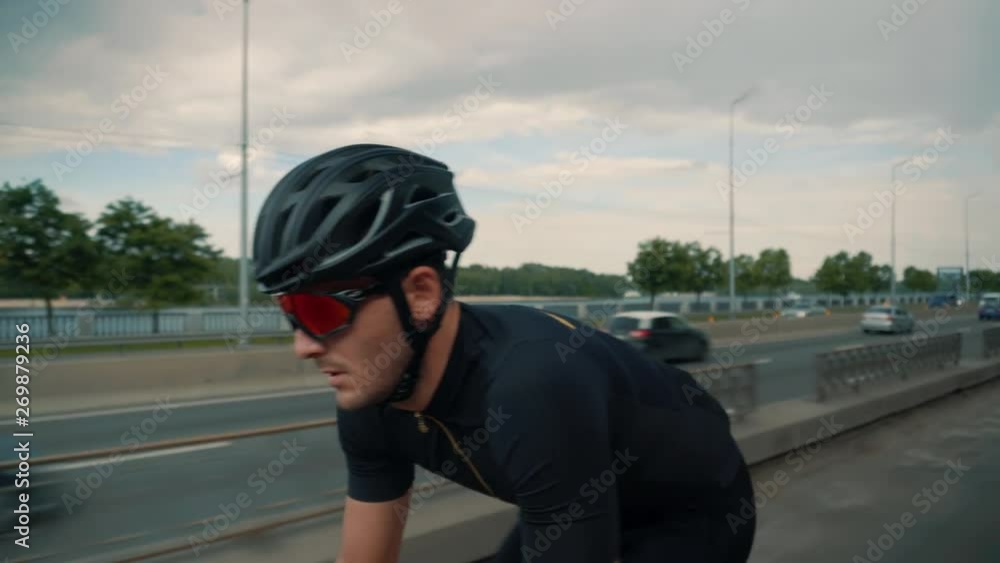 Cyclist Cycling On Road Bicycle Before Triathlon.Bicycle Wheel Close Up.Triathlete Twists Pedals On Bike.Gear System Road Bicycle.Athlete Cyclist Riding On Carbon Bicycle.Cyclists Riding At Sunset. Cyclist Cycling On Road Bicycle Before Triathlon.Bicycle Wheel Close Up.Triathlete Twists Pedals On Bike.Gear System Road Bicycle.Athlete Cyclist Riding On Carbon Bicycle.Cyclists Riding At Sunset.