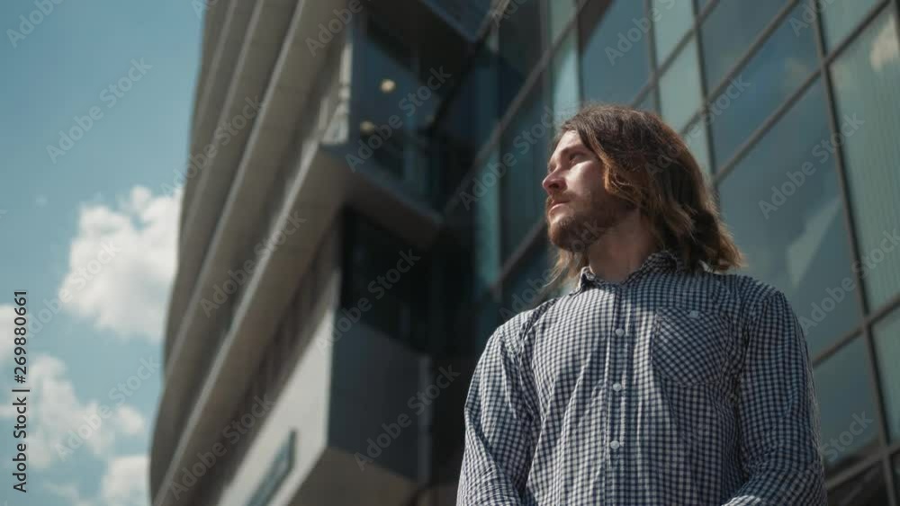 Young man smiling near office building outdoor. Portrait of happy handsome young student guy in urban street. Young man smiling near office building outdoor. Portrait of happy handsome young student guy in urban street.