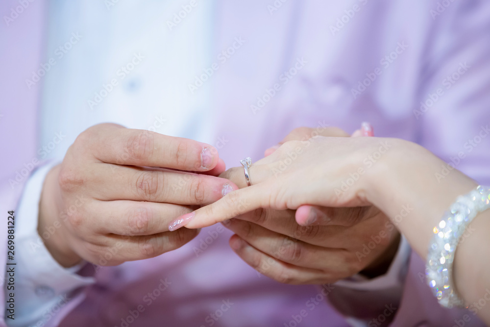 Wedding rings. He Put the Wedding Ring on Her. Close up Groom Put the Ring on bride. thai wedding ceremony and thai wedding decoration.  Groom Put the Ring on bride's finger.