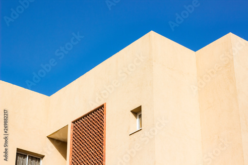 geometry pattern of bright rose house roof corners and architectural shapes on vivid blue sky background 
