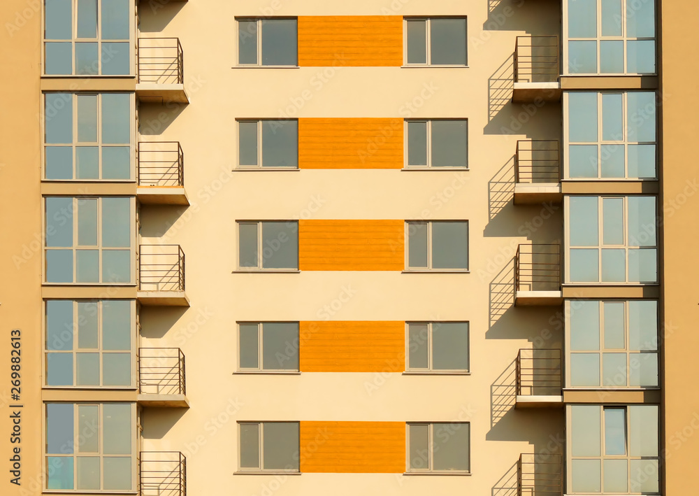 Fragment of symmetric exterior of modern multi apartment residential building.