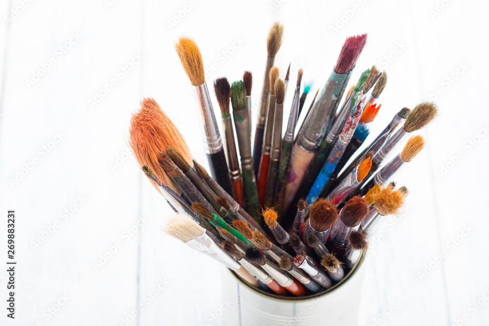 bunch of paint brush at tin can, on white wooden bunch of paint brush at tin can, on white wooden