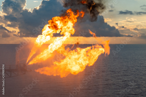 Well testing operation (flaring) of an oil and gas drilling rig. Burning huge gas flame controlled by the deluge system photo