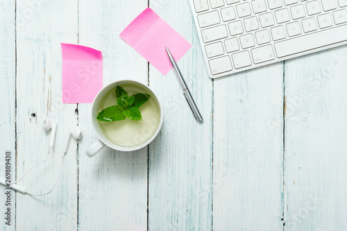 work place with cup of mint tea, pink post its and pen, directly above