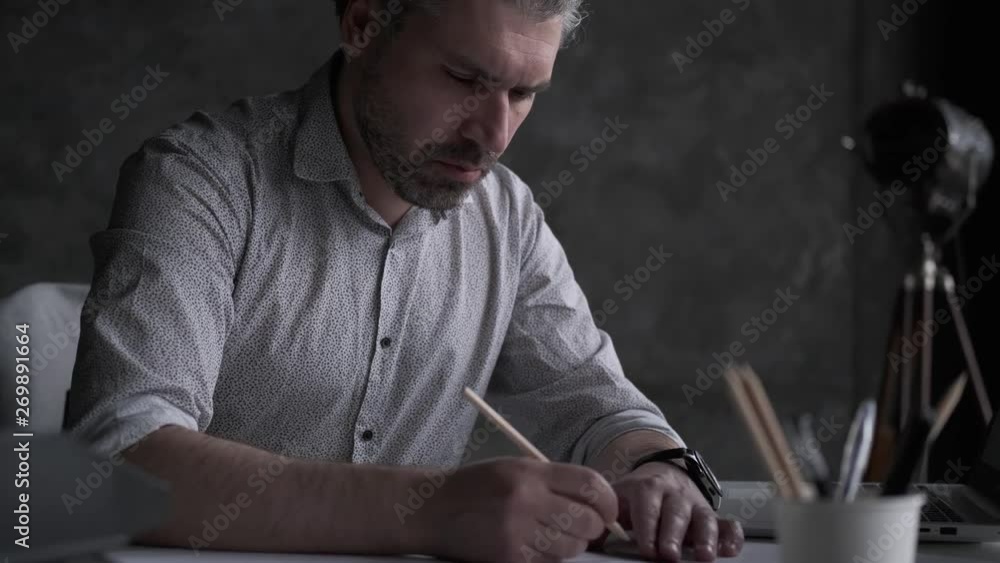 architect works with plans and documents. man at his desk in the office. architect works with plans and documents. man at his desk in the office.