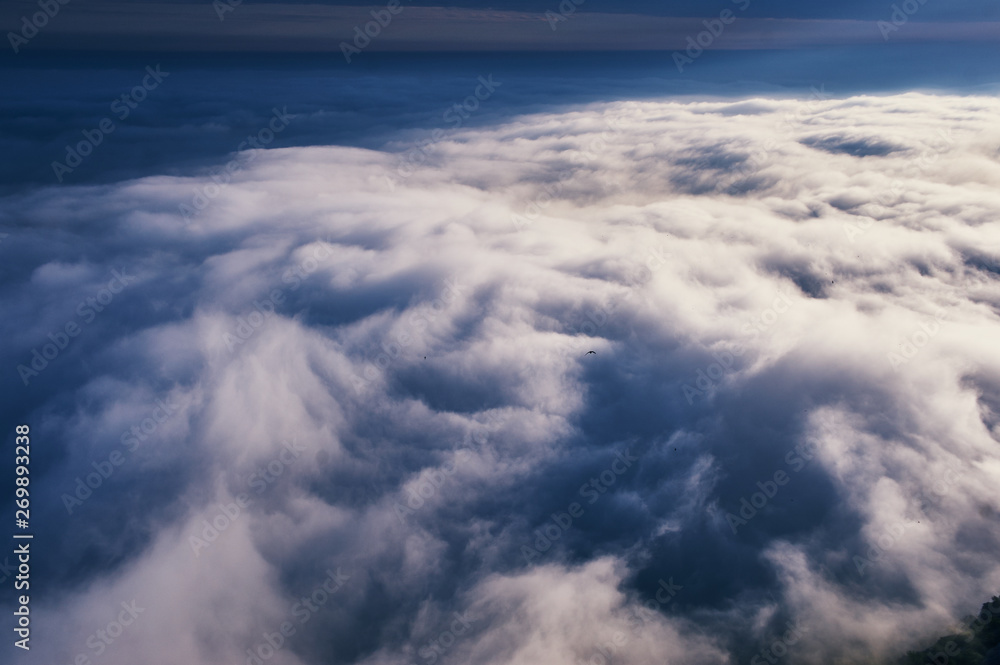 above the clouds cloudscape. cloudy weather in the mountains. blue sky aerial view background.
