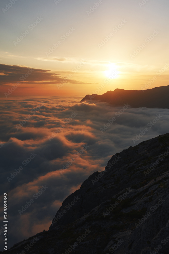 beautiful sunset above the clouds in the mountains. stunned landscape background with copy space. aerial mountain view. vertical