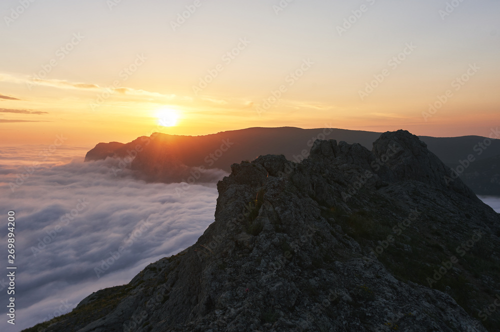 beautiful sunset above the clouds in the mountains. stunned landscape background with copy space. aerial mountain view