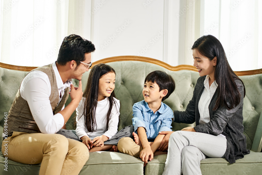 asian parents and two children chatting at home asian parents and two children chatting at home