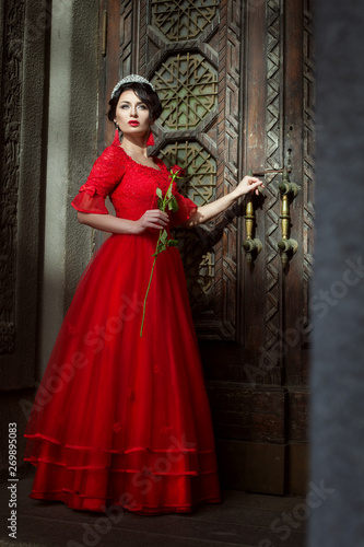 Princess on the background of the doors to the castle, in her hand a red rose.