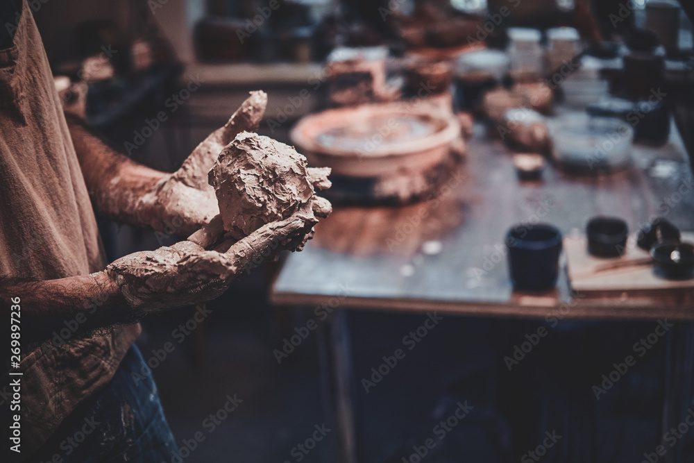 Closeup photoshoot of working process with clay by diligent man.