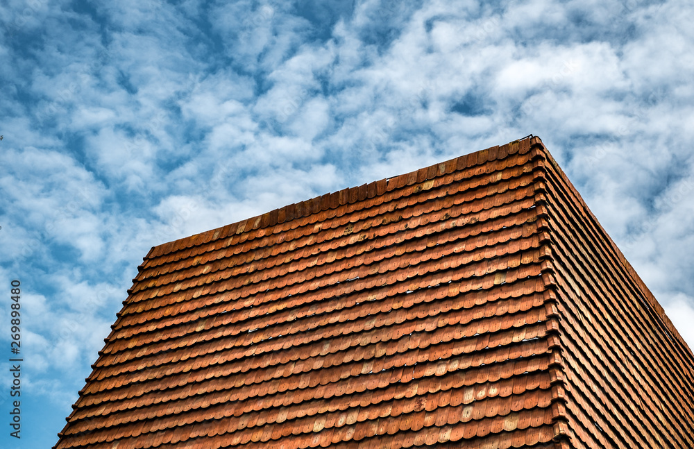 red roof tile on cloudy sky