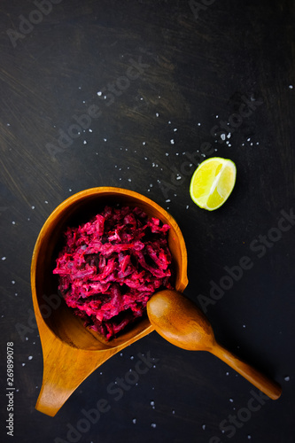 Hummus from beets in rustic dishes and lime on a dark background. Levante israeli cuisine. Top view. Vertical