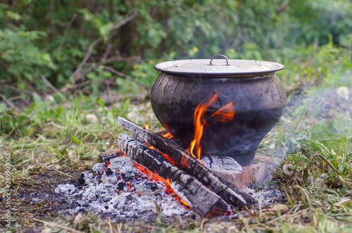 Cast iron on the fire, close-up. People resting in nature, lit a fire and cooked on it in fish soup.