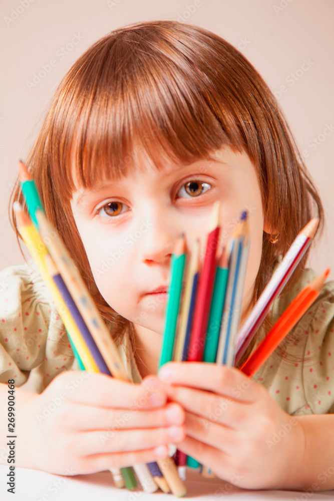 Great artist. Portrait of cute little child girl with colored pencils.