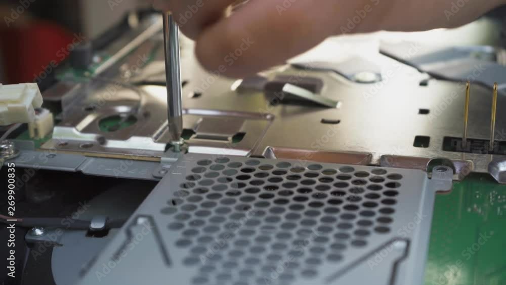 The worker unscrews with a screwdriver and pulls out the cooling system The worker unscrews with a screwdriver and pulls out the cooling system