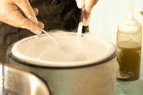 Two spoons extracting food fromliquid nitrogen with steam and mist