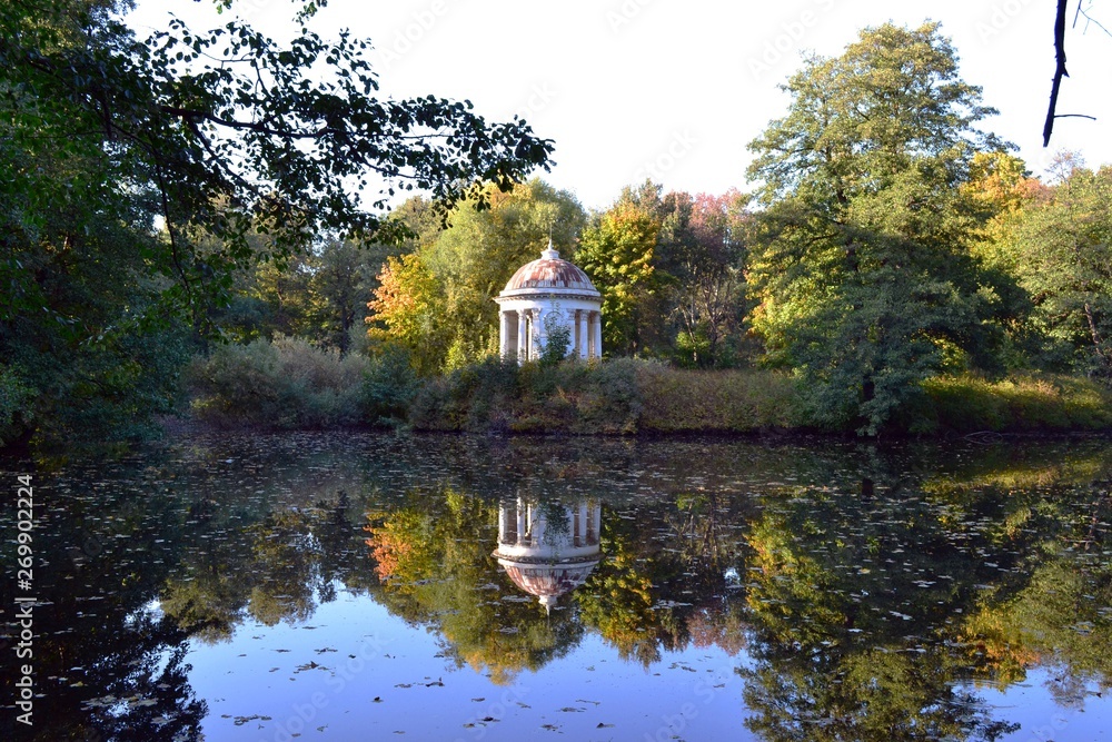 Old gazebo near the pond in the park on the background of beautiful autumn trees. Old gazebo near the pond in the park on the background of beautiful autumn trees.