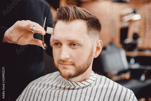 Barbershop, man barber in men hairdresser does hair with scissors