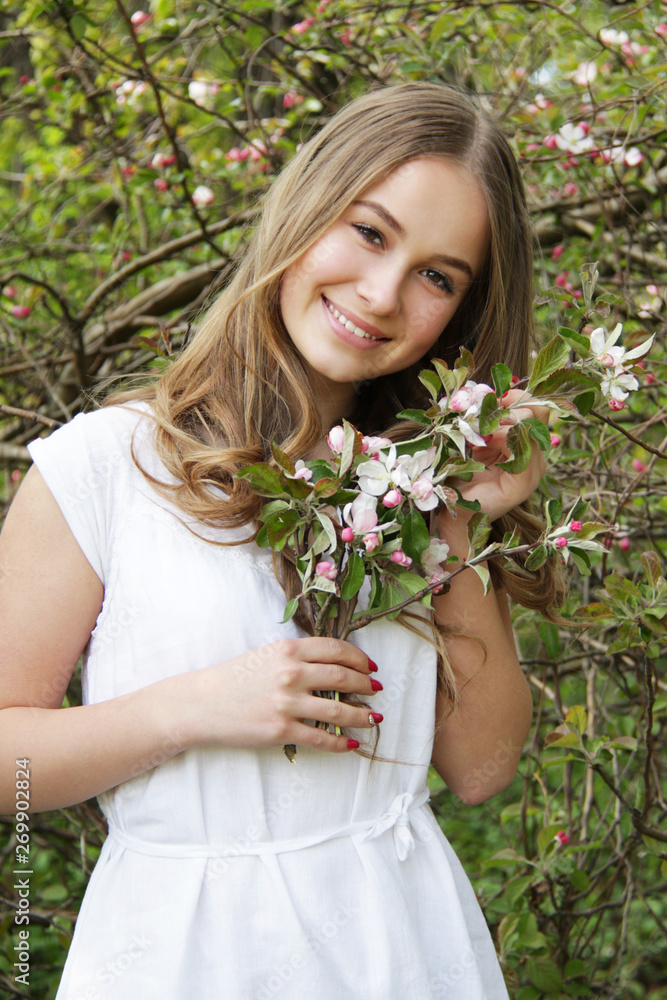 © Iveta - Young caucasian girl in white linen dress stay in apple garden and smile © Iveta - Young caucasian girl in white linen dress stay in apple garden and smile