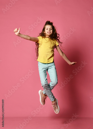 Young lady or teen girl in jeans and yellow t-shirt has fun taking