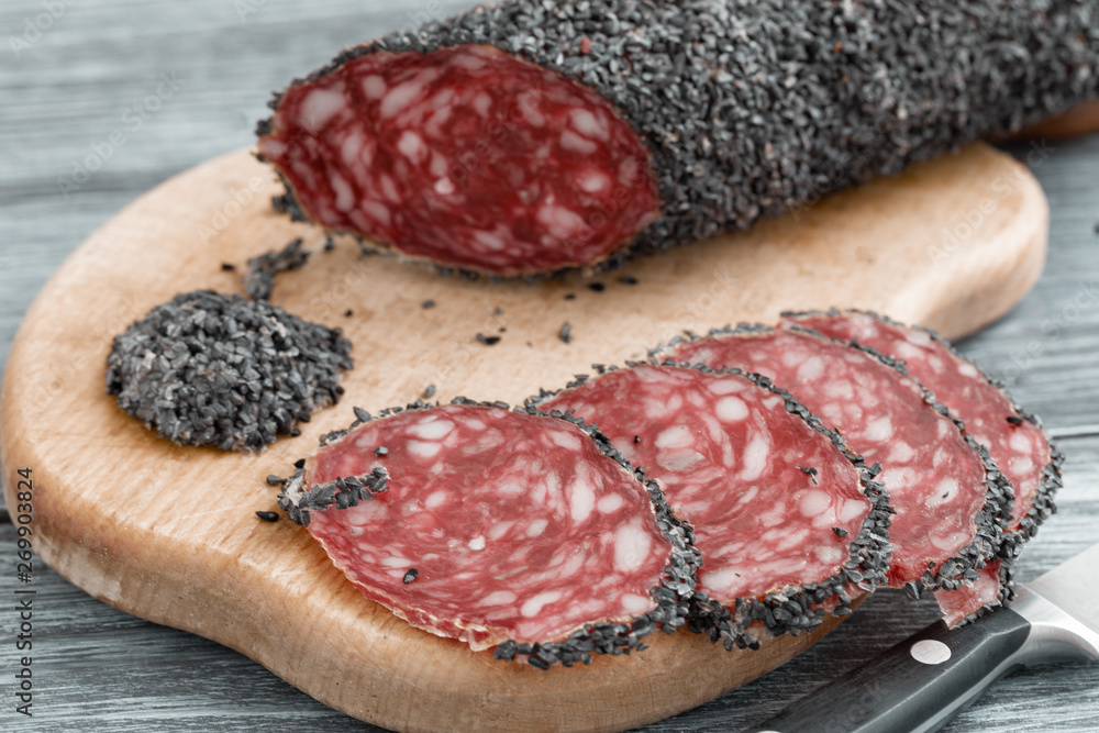 Uncooked smoked sausage with a red cut on a wooden cutting board Uncooked smoked sausage with a red cut on a wooden cutting board