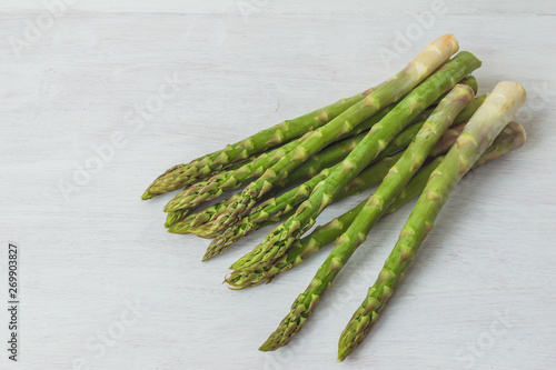 Group of raw green asparagus on a white background with space for copy text