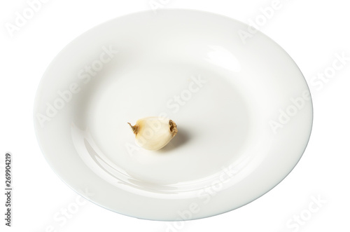 A white plate with a slice of garlic isolated on white