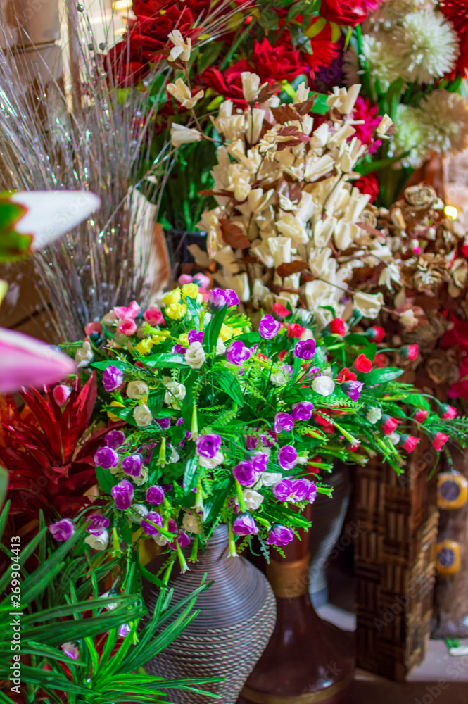 Plastic flowers and green leaves with exotic colors