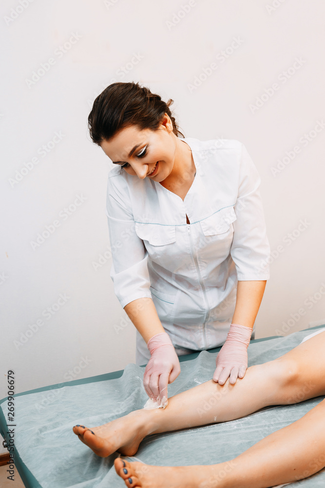 Woman having hair removal procedure on leg with sugaring paste Woman having hair removal procedure on leg with sugaring paste