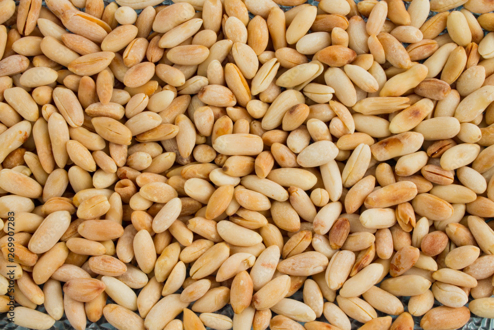 background of small roasted peanuts scattered on a ceramic plate. background of small roasted peanuts scattered on a ceramic plate.