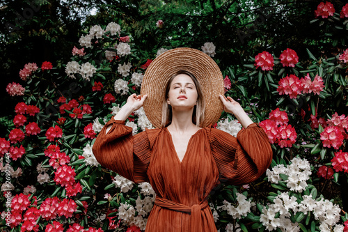 style woman near rhododendron flowers in a grarden in spring time photo