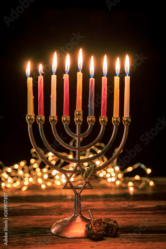 Concept of jewish holiday Hanukkah with menorah (traditional candelabra) and burning candles. photo